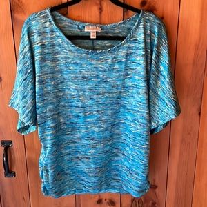 Woman’s short sleeve multi colored blues. Puckered lower sides.